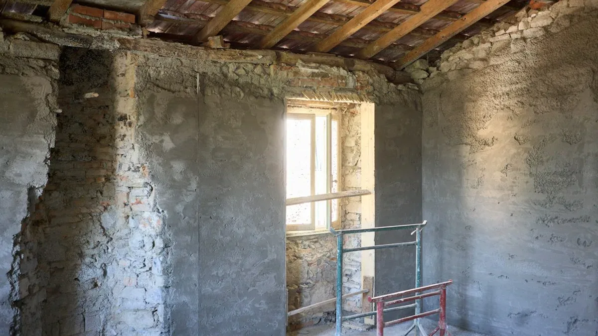 déshumidificateur chantier — un déshumidificateur de chantier posé dans une pièce en rénovation aux murs fraîchement enduits, lumière naturelle, tons chauds