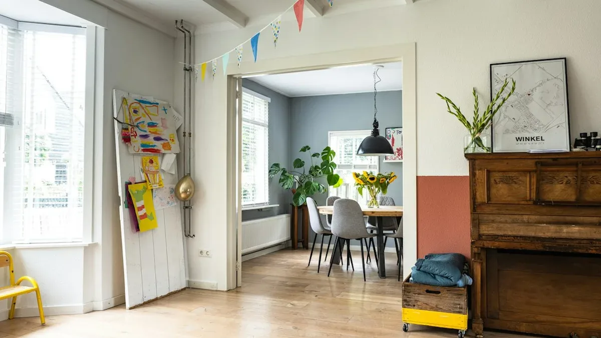 humidité appartement — un salon d'appartement français lumineux, hygromètre posé sur une étagère près d'une fenêtre légèrement embuée, tons terracotta et bois
